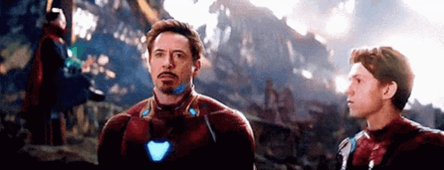 tony stark and spider-man are standing next to each other in a scene from avengers : endgame .