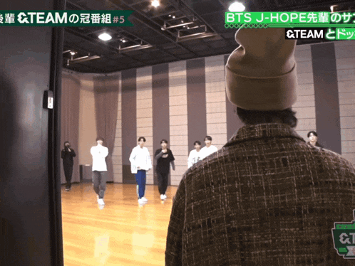a group of people are dancing in a room with a sign that says team