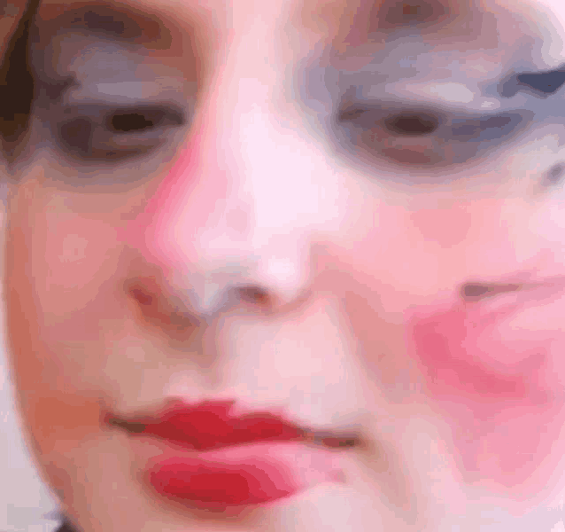 a close up of a woman 's face with a lot of makeup on .