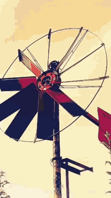 a red and black windmill is against a yellow background