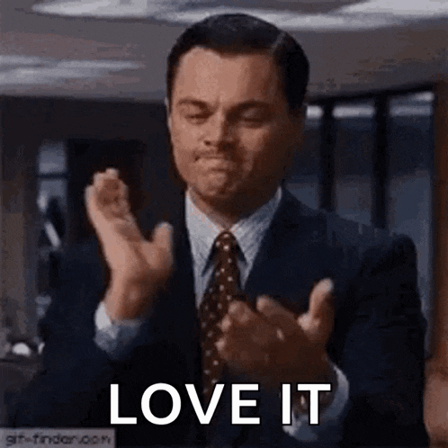 a man in a suit and tie is clapping his hands with the words `` love it '' .