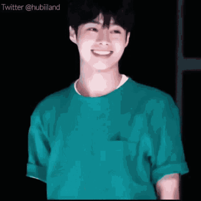 a young man in a green t-shirt is smiling .