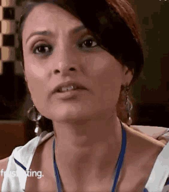 a close up of a woman 's face with a blue lanyard around her neck .