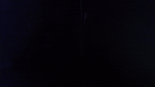 a man wearing headphones is making a funny face in the dark