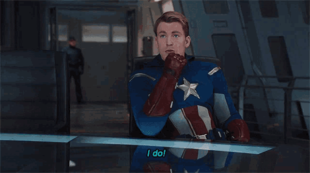 a man in a captain america costume is pointing at the camera