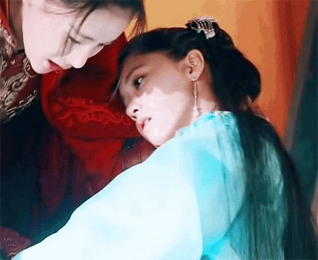 two women are standing next to each other and one is wearing a blue dress