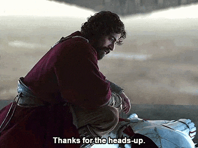 a man with a beard is standing next to a car and says `` thanks for the heads up '' .