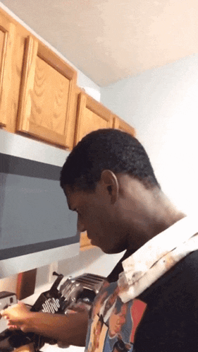 a man wearing a t-shirt with a picture of michael jackson cooking in a kitchen