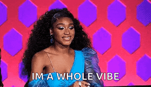 a woman in a blue dress is saying `` i 'm a whole vibe '' while sitting on a stage .