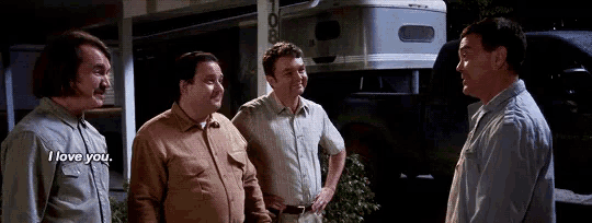 a group of men are standing in front of a trailer and talking to each other .