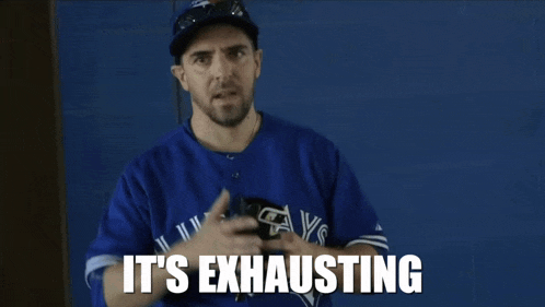 a man wearing a blue jays jersey is exhausted
