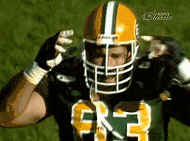 a green bay packers player wearing a yellow helmet