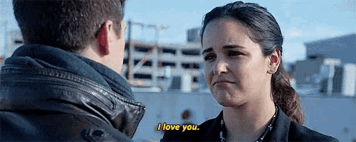 a man and woman are looking at each other and the woman is saying i love you .