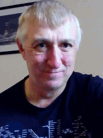 a man wearing a black shirt with a city on it is smiling