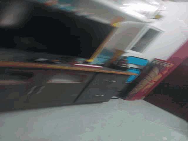 a blurred image of a room with a refrigerator and a mattress