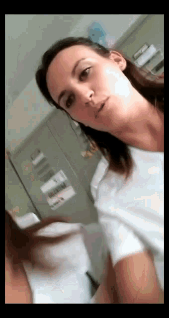 a woman in a white shirt is standing in front of a mirror
