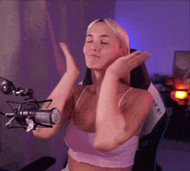 a woman in a pink top is sitting in front of a microphone that says aeris on it