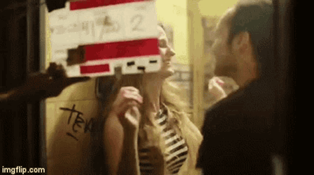 a man and woman are standing in front of a sign that says tea on it