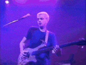 a man is playing a guitar in a dark room