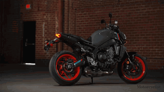 a motorcycle is parked in front of a brick wall with the words motorcyclist on the bottom