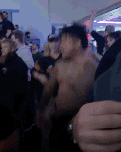 a group of people are dancing in a dark room