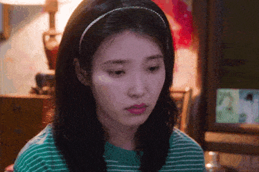 a woman wearing a green and white striped shirt and a headband