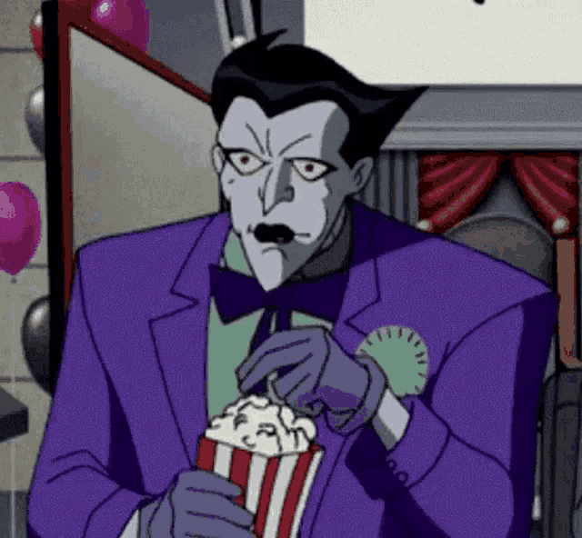 the joker is eating popcorn from a popcorn box .