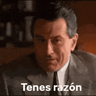 a man in a suit and tie is looking at the camera with the words tenes razon below him