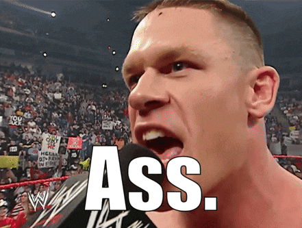 a wrestler is screaming into a microphone with the word ass written on it