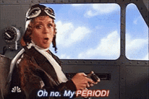 a woman wearing a helmet and goggles is sitting in a plane and says oh no my period