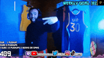 a man is pointing at a curry jersey hanging on a wall