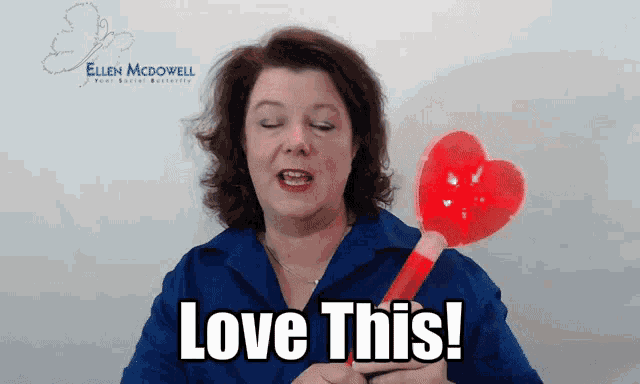 a woman holding a red heart shaped object with the words love this behind her