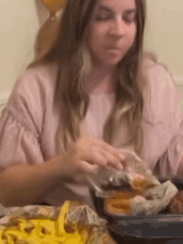 a woman is sitting at a table eating french fries