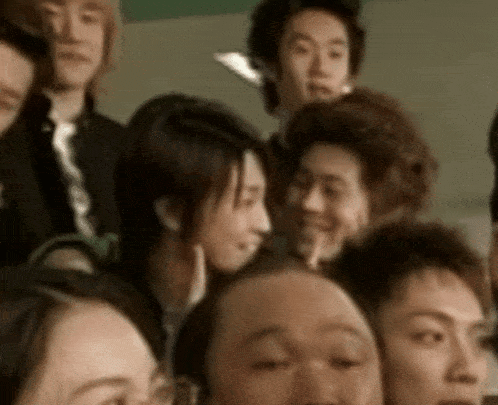 a group of people are posing for a picture and one of them has a hand on her chin