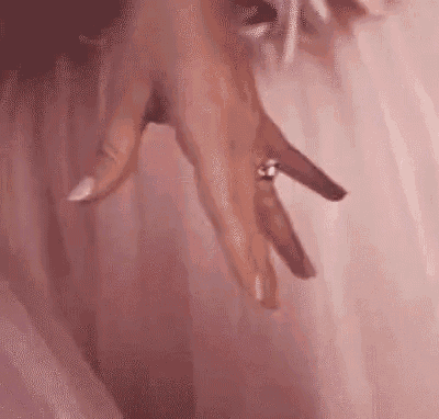 a close up of a woman 's hand with a ring on her finger .