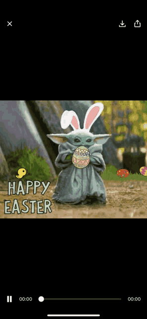 a baby yoda wearing bunny ears and holding an easter egg