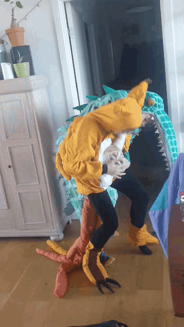 a person in a dinosaur costume is holding a child