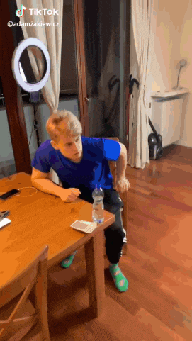 a man sitting at a table with a bottle of water