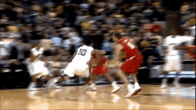 a basketball player with the number 10 on his jersey dribbles the ball