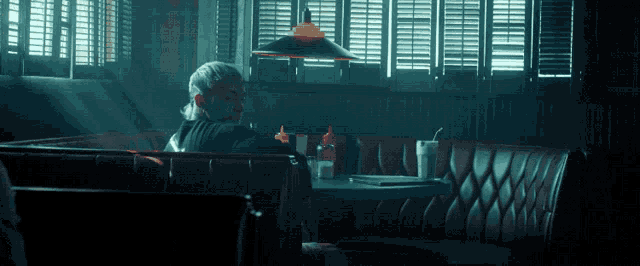 a man sits at a table in a diner