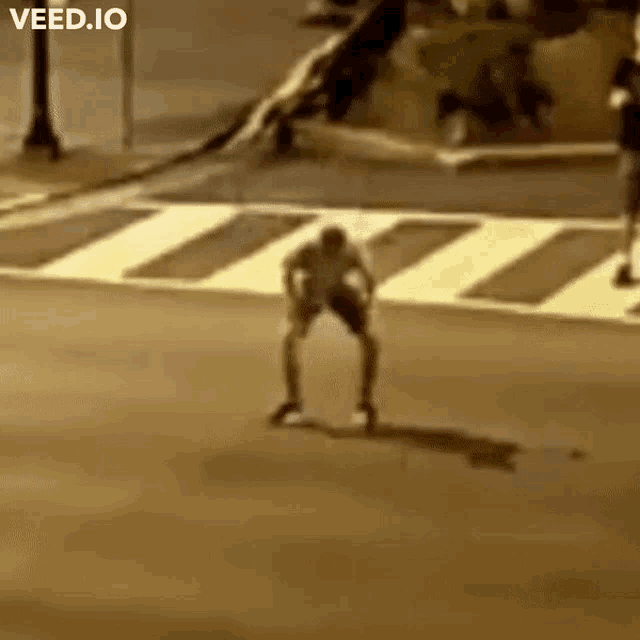 a man is walking across a crosswalk with the words veed.io written on the bottom