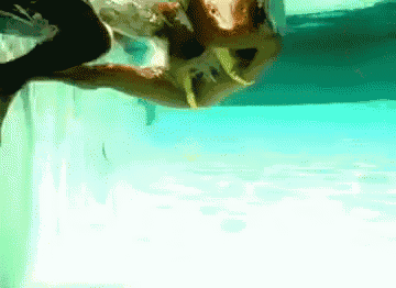 a woman in a bikini is swimming in a swimming pool
