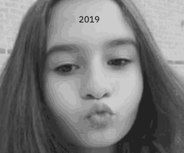 a young girl is making a funny face in a black and white photo .