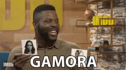 a man is holding a picture of a woman and the word gamora is on it