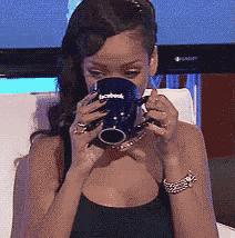 a woman drinking from a blue mug that says facebook on it