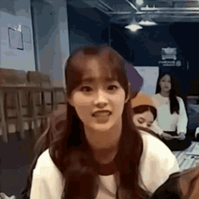 a girl is making a funny face in a room with other girls .