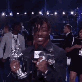 a man is holding a trophy in front of a crowd at a concert .