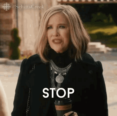 a woman is holding a cup of coffee and the word stop is above her