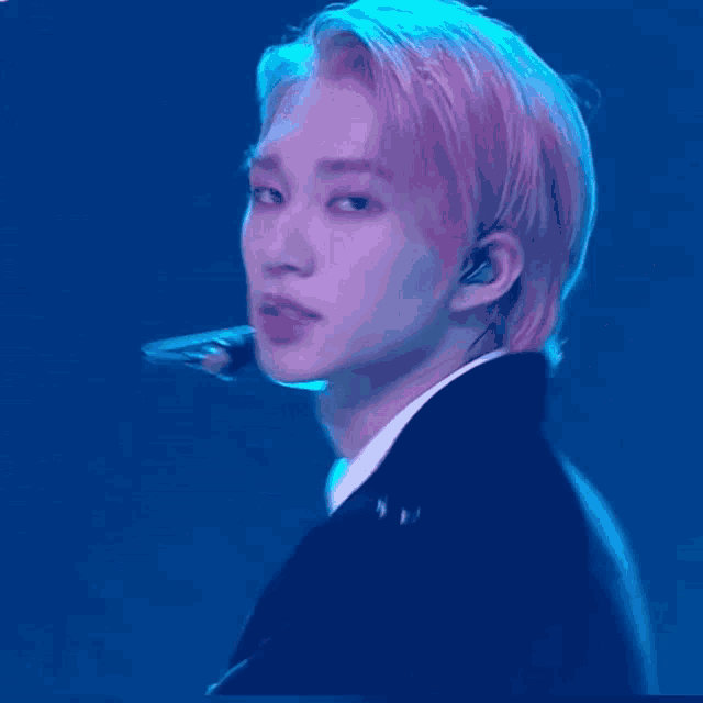 a man with pink hair is wearing earphones and a microphone