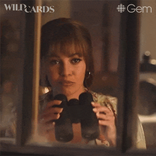 a woman is looking through binoculars with wildcards written on the bottom